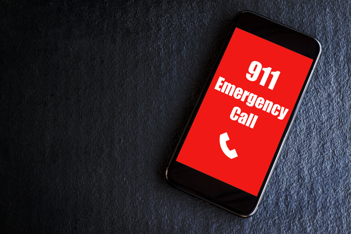 black cell phone with red screen and white writing that reads "911 Emergency Call"
